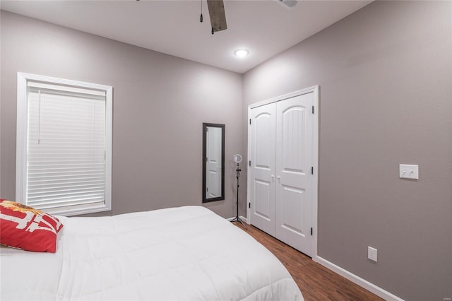 bedroom with wood finished floors, baseboards, a closet, and ceiling fan
