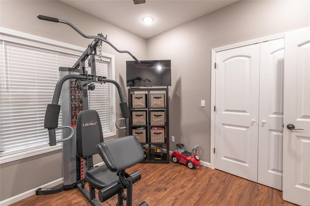 workout area featuring wood finished floors and baseboards