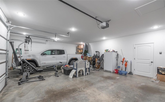 garage featuring a garage door opener, freestanding refrigerator, and recessed lighting