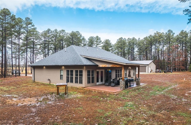 back of house with a shingled roof and a patio