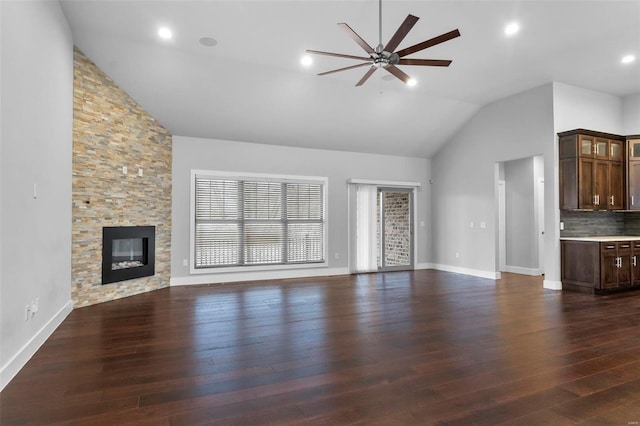 1661 Helmsdale Cpe, Girardeau, MO 63701 - unfurnished living room featuring ceiling fan, a stone fireplace, dark wood finished floors, baseboards, and high vaulted ceiling