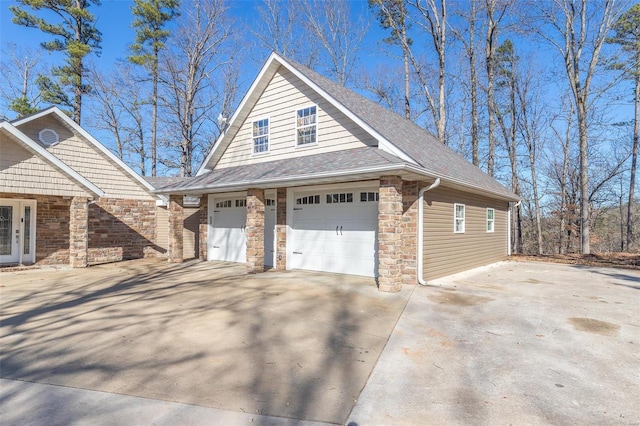 14178 E US Highway 60, Van Buren, MO 63965 - view of side of property with a garage, a shingled roof, stone siding, and concrete driveway