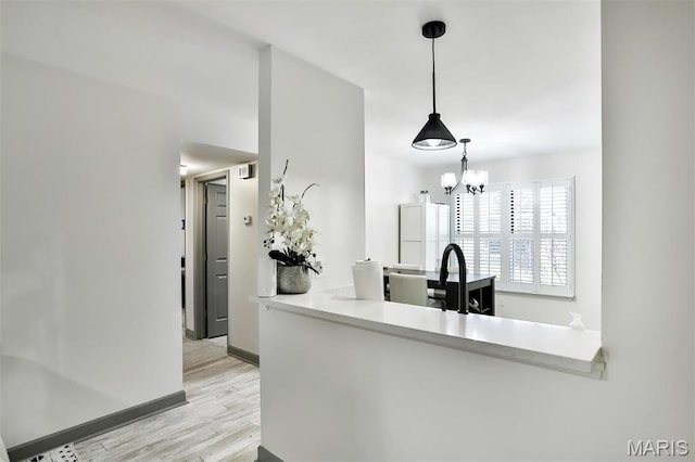 915 Sugar Lake Ct Unit 4, Saint Peters, MO 63376 - kitchen featuring wood finished floors, baseboards, a chandelier, hanging light fixtures, and a sink