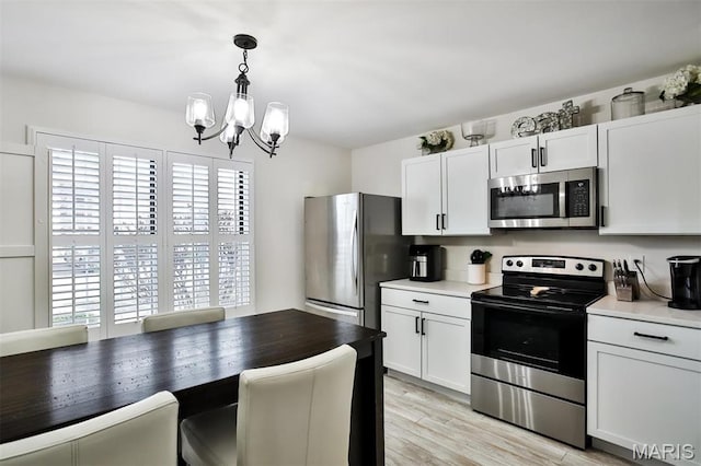 915 Sugar Lake Ct Unit 4, Saint Peters, MO 63376 - kitchen featuring appliances with stainless steel finishes, a chandelier, light countertops, and decorative light fixtures