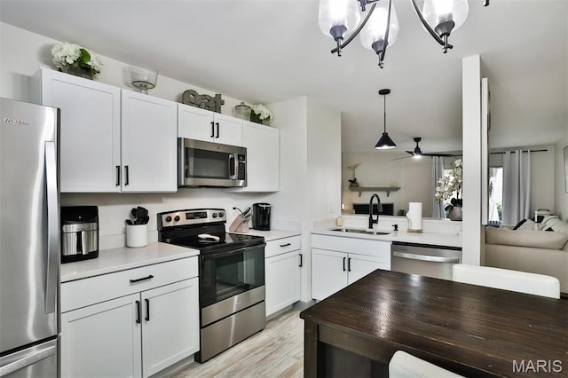 915 Sugar Lake Ct Unit 4, Saint Peters, MO 63376 - kitchen featuring stainless steel appliances, a sink, light wood-style floors, open floor plan, and pendant lighting