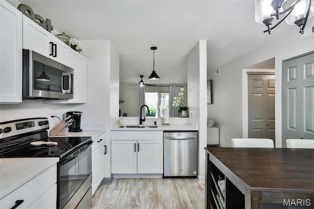 915 Sugar Lake Ct Unit 4, Saint Peters, MO 63376 - kitchen featuring stainless steel appliances, a sink, light wood-style floors, hanging light fixtures, and white cabinetry