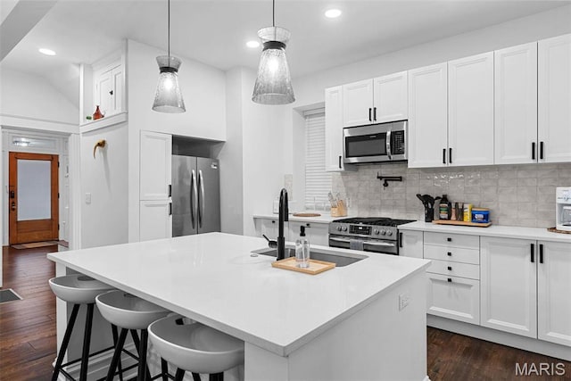 3223 Geyer Ave, Saint Louis, MO 63104 - kitchen with appliances with stainless steel finishes, a sink, dark wood-type flooring, decorative backsplash, and white cabinets