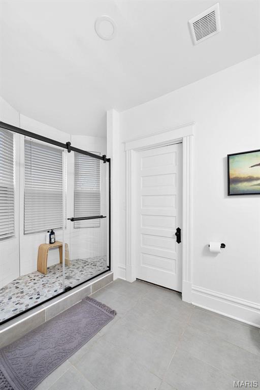 3223 Geyer Ave, Saint Louis, MO 63104 - full bathroom with a stall shower, tile patterned floors, and baseboards