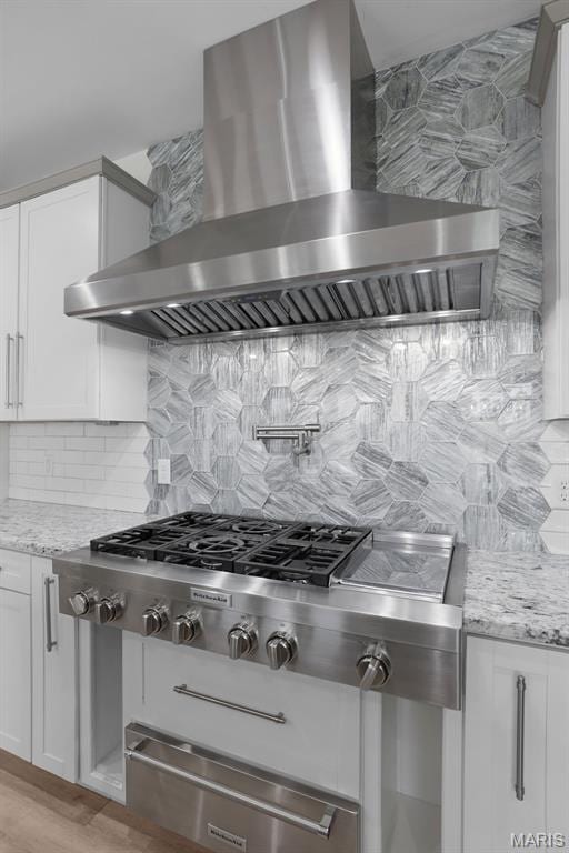 215 Wyndemere Ln, Lake St Louis, MO 63367 - kitchen with wall chimney exhaust hood, decorative backsplash, a warming drawer, white cabinets, and light stone counters