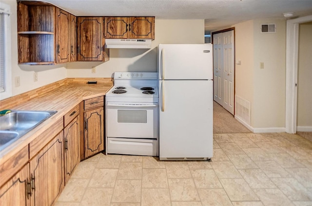 106 N Market St, Waterloo, IL 62298 - kitchen with white appliances, under cabinet range hood, open shelves, and brown cabinets