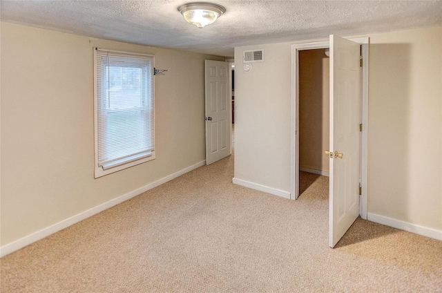 106 N Market St, Waterloo, IL 62298 - spare room featuring a textured ceiling, light colored carpet, and baseboards