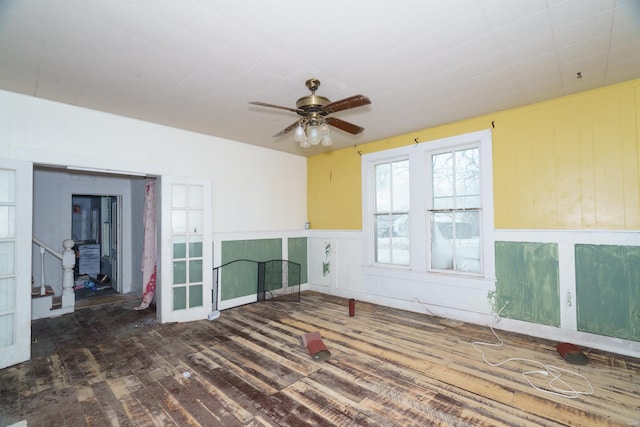 212 N Main St, Licking, MO 65542 - unfurnished room featuring wood finished floors, ceiling fan, wainscoting, and a decorative wall