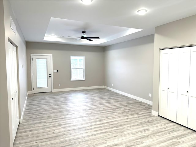 344 Rolling Knoll Rd, Washington, MO 63090 - unfurnished living room with a tray ceiling, a ceiling fan, light wood-style flooring, and baseboards