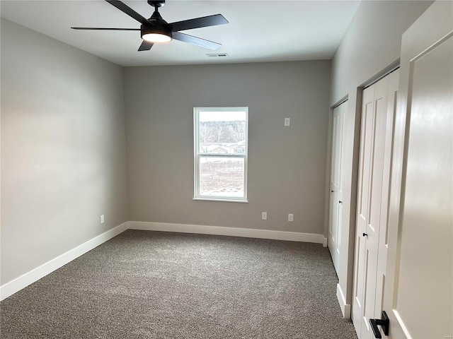 344 Rolling Knoll Rd, Washington, MO 63090 - unfurnished bedroom featuring multiple closets, dark carpet, baseboards, and a ceiling fan