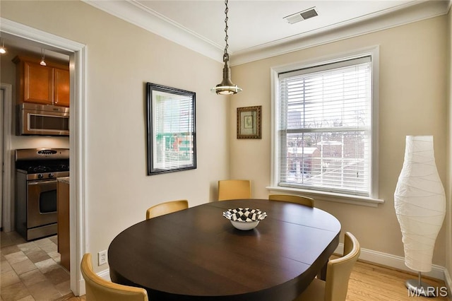 dining area with baseboards and crown molding