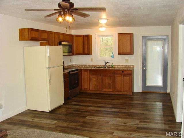 715 W Broadway, Sparta, IL 62288 - kitchen with freestanding refrigerator, stainless steel microwave, electric range oven, brown cabinets, and a textured ceiling