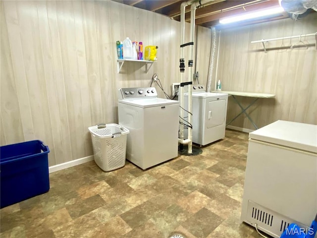 914 Pine St, Sikeston, MO 63801 - laundry room with washer and clothes dryer, wood walls, baseboards, and stone finish floors