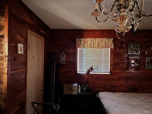 731 Buffalo Dr, Bismarck, MO 63624 - bedroom with wood walls, a chandelier, and a textured ceiling