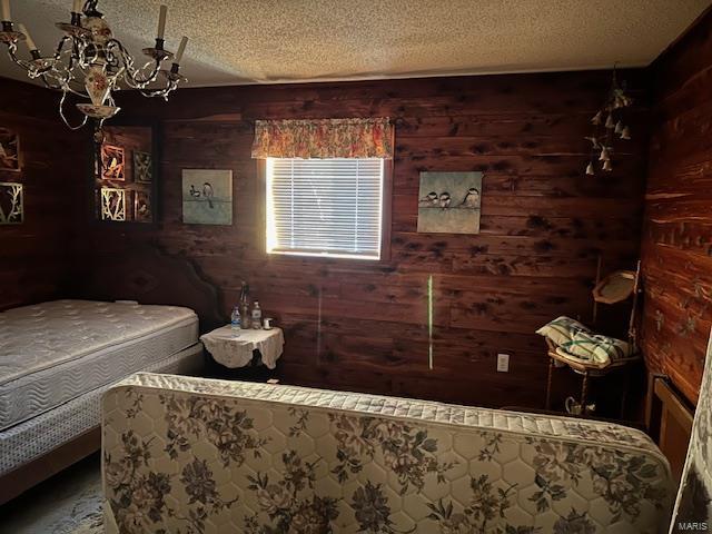 731 Buffalo Dr, Bismarck, MO 63624 - bedroom featuring wooden walls, a textured ceiling, and a chandelier