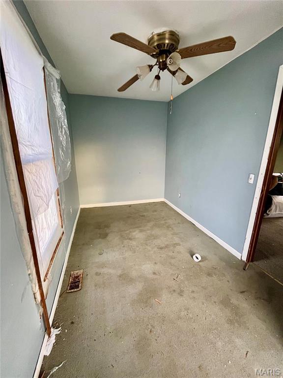 209 Mcgill St, Jerseyville, IL 62052 - unfurnished room with baseboards, ceiling fan, and concrete flooring