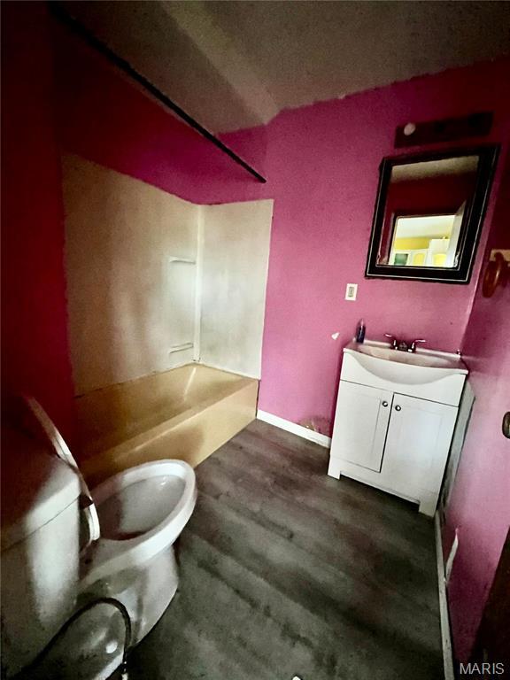 209 Mcgill St, Jerseyville, IL 62052 - bathroom featuring toilet, vanity, wood finished floors, and bathtub / shower combination