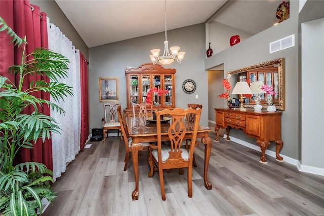 213 Kimberly Ct, Washington, MO 63090 - dining room with a chandelier, light wood-style flooring, high vaulted ceiling, and baseboards