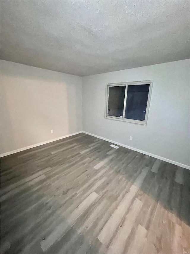 12065 El Camara Dr, Florissant, MO 63033 - unfurnished room with dark wood-style flooring, baseboards, and a textured ceiling