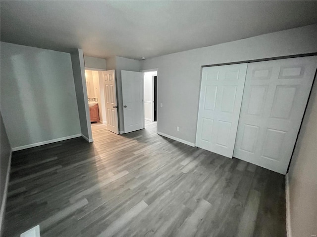 12065 El Camara Dr, Florissant, MO 63033 - unfurnished bedroom with dark wood-style flooring, baseboards, a closet, and ensuite bath