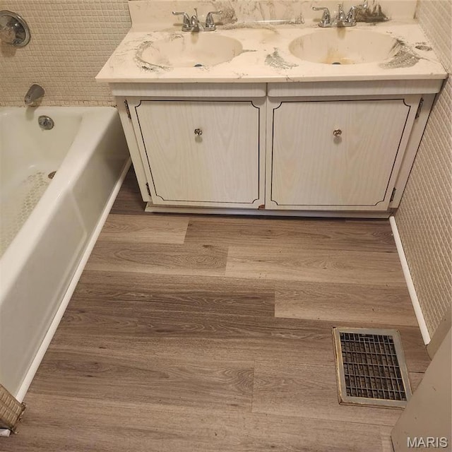 7120 Bancroft Ave, Saint Louis, MO 63109 - bathroom with wood finished floors, double vanity, a tub, and wallpapered walls