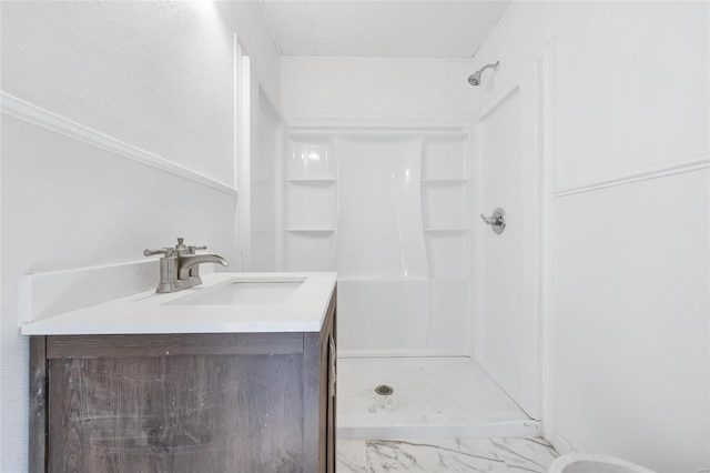 bathroom with a shower stall, marble finish flooring, and vanity