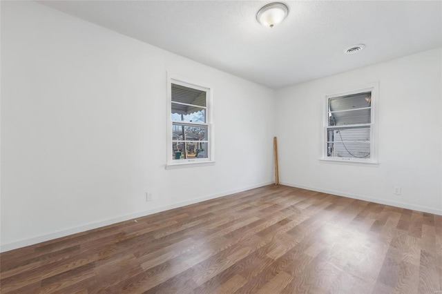 spare room with wood finished floors and baseboards