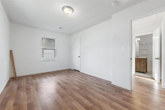 unfurnished bedroom with wood finished floors and baseboards
