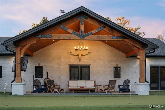 1824 Topping Rd, Saint Louis, MO 63131 - back of house at dusk featuring a putting green, brick siding, and a patio