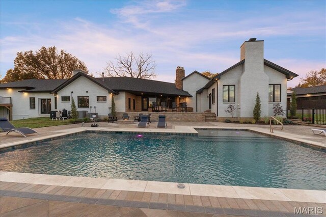 1824 Topping Rd, Saint Louis, MO 63131 - pool at dusk featuring a patio and fence