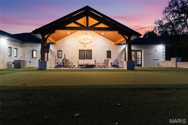 1824 Topping Rd, Saint Louis, MO 63131 - back of house at dusk with a putting green, central AC, a patio, and french doors