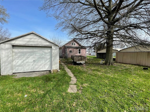 101 Cass St, Waterloo, IL 62298 - view of green lawn with an outbuilding, a detached garage, and driveway