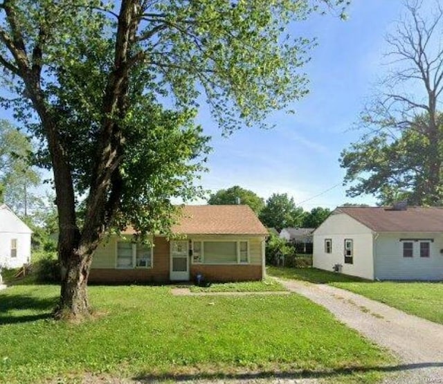 view of front of house featuring a front lawn and dirt driveway
