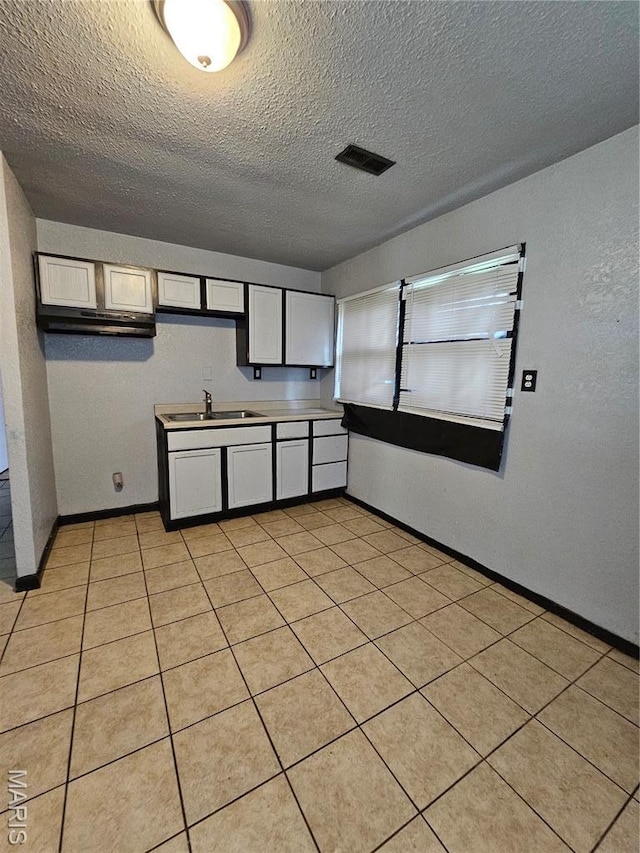 12 Agnes Dr, Cahokia, IL 62206 - kitchen featuring a textured ceiling, light tile patterned floors, and white cabinets