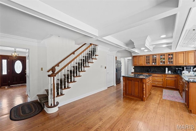 kitchen featuring brown cabinetry, dark countertops, a center island, recessed lighting, and light wood finished floors