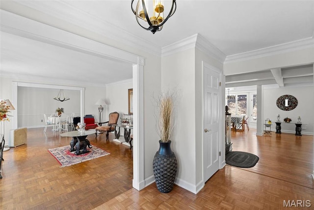 foyer entrance featuring baseboards, crown molding, and a chandelier