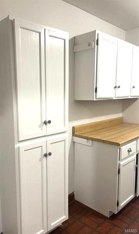 kitchen with brick flooring and white cabinets