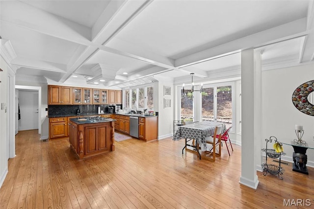 kitchen with brown cabinets, appliances with stainless steel finishes, light wood-type flooring, a kitchen island, and coffered ceiling