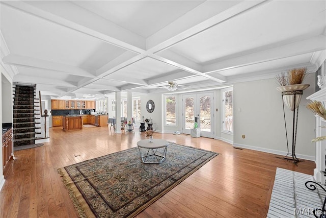 living room featuring light wood-type flooring, stairway, coffered ceiling, a ceiling fan, and baseboards