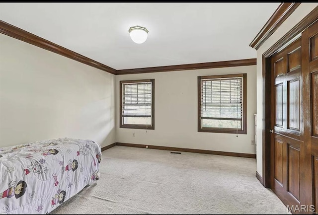 bedroom with light colored carpet, ornamental molding, and baseboards