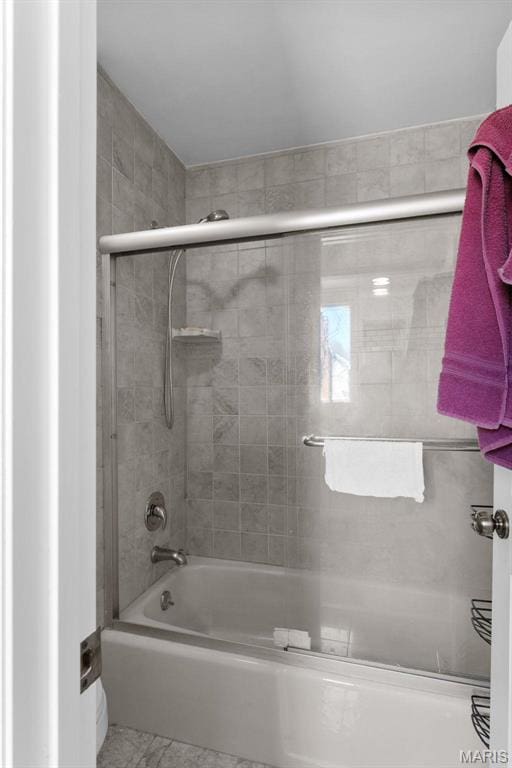 bathroom with bath / shower combo with glass door