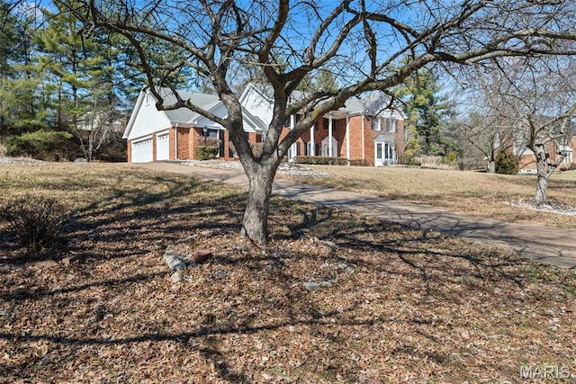 view of front of house featuring brick siding, an attached garage, and driveway
