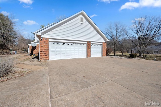 view of property exterior featuring driveway and brick siding