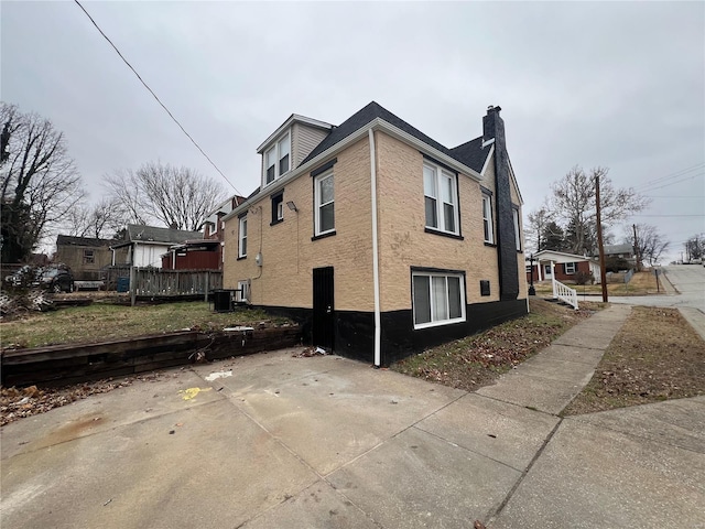7100 Lexington Ave, Saint Louis, MO 63121 - view of home's exterior with a chimney, a patio area, and central air condition unit