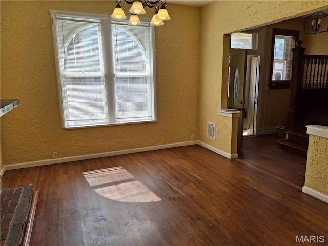 2709 Keokuk St, Saint Louis, MO 63118 - unfurnished dining area featuring a chandelier, wood finished floors, baseboards, and a textured wall