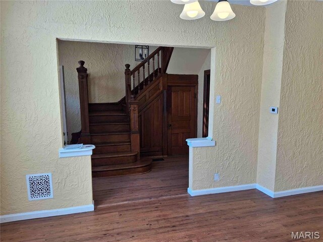 2709 Keokuk St, Saint Louis, MO 63118 - stairs with a textured wall, wood finished floors, and baseboards